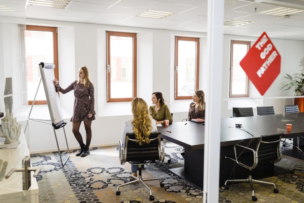 Vrouw geeft presentatie aan T&P collega's